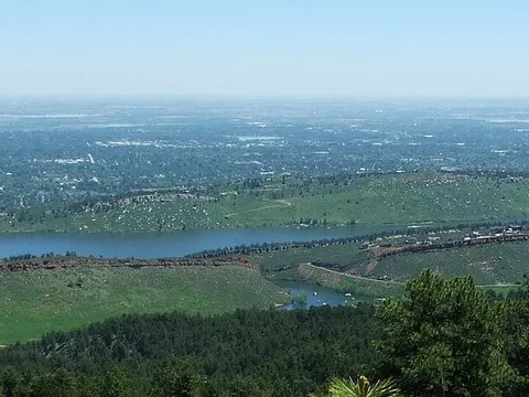 Horsetooth Reservoir from the ridge above it, the long lake between hogbacks with Fort Collins spread across the plains beyond