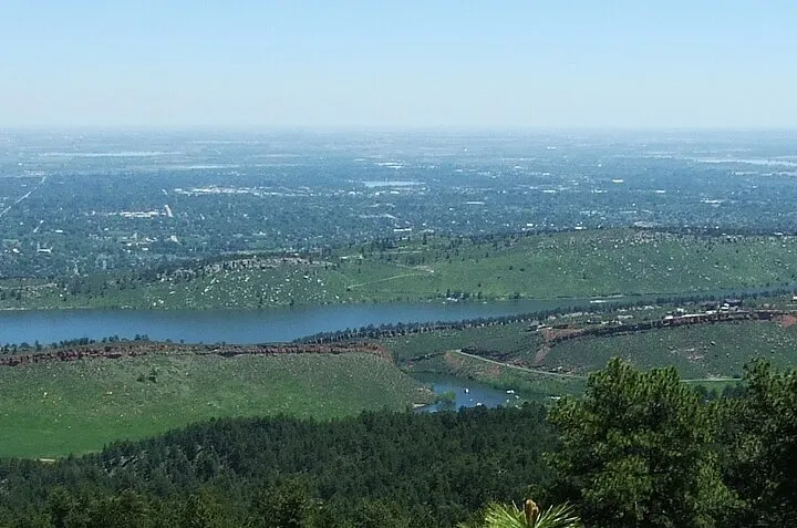 Horsetooth Reservoir from the ridge above it, the long lake between hogbacks with Fort Collins spread across the plains beyond
