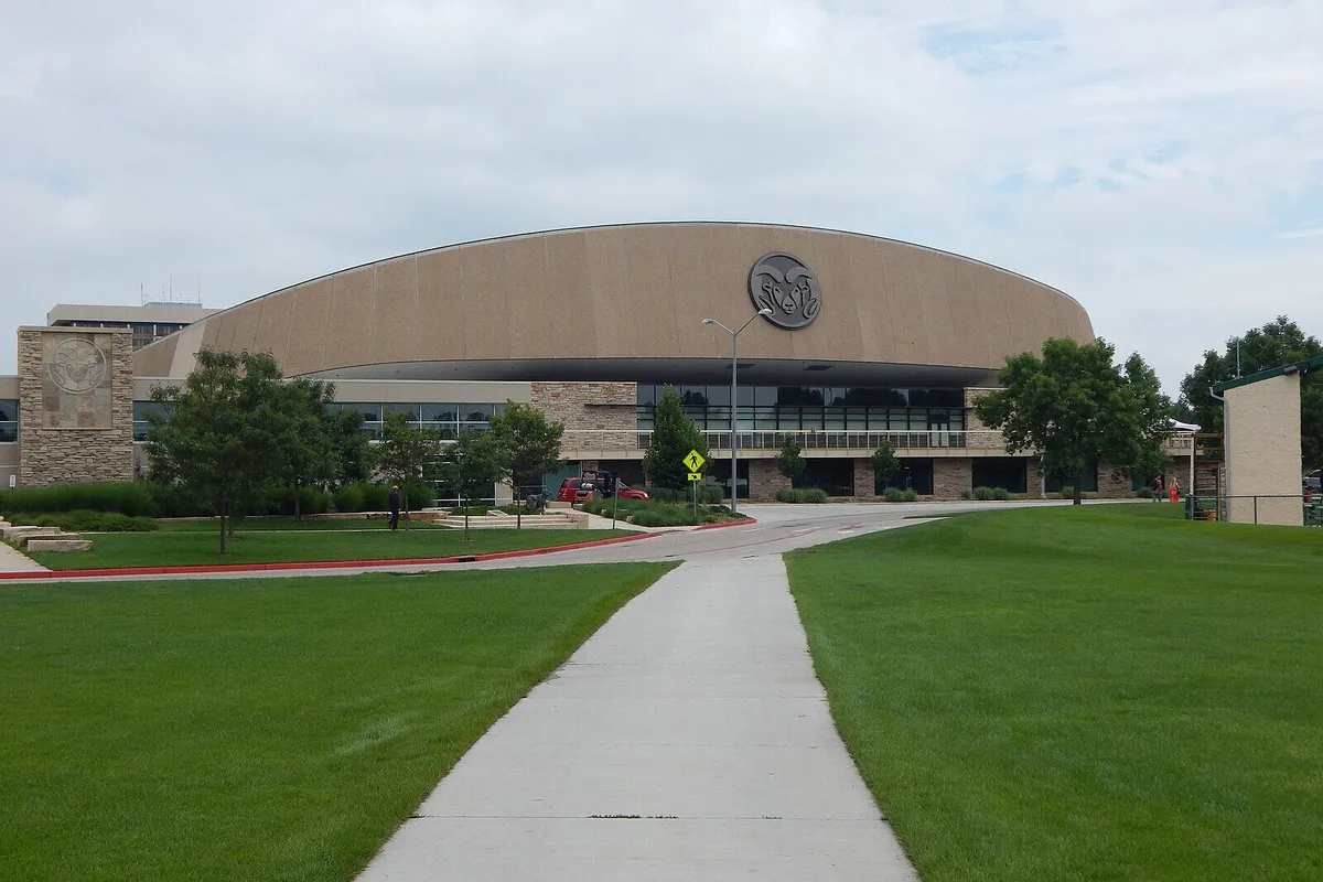 The domed, tan-coloured Moby Arena with the CSU ram logo on its front, seen down a concrete path across a lawn.